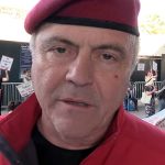 Curtis Sliwa in his signature red beret with his mouth slightly agape.