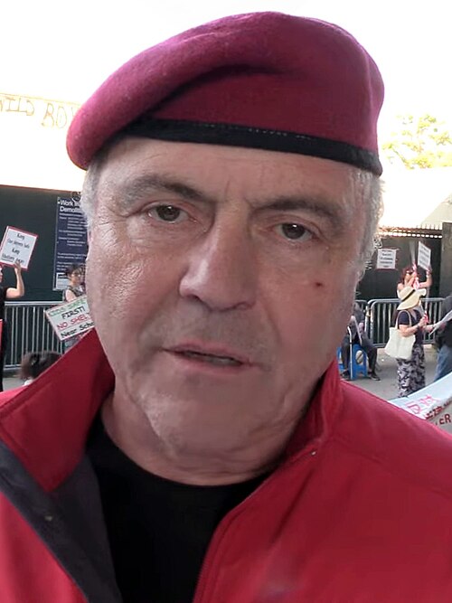 Curtis Sliwa in his signature red beret with his mouth slightly agape.
