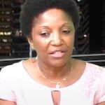 Photo of Mercedes Narcisse, with short hair and a white or light pink shirt, looking down and to the left, clearly thinking deeply about how to make the city better for her constituents